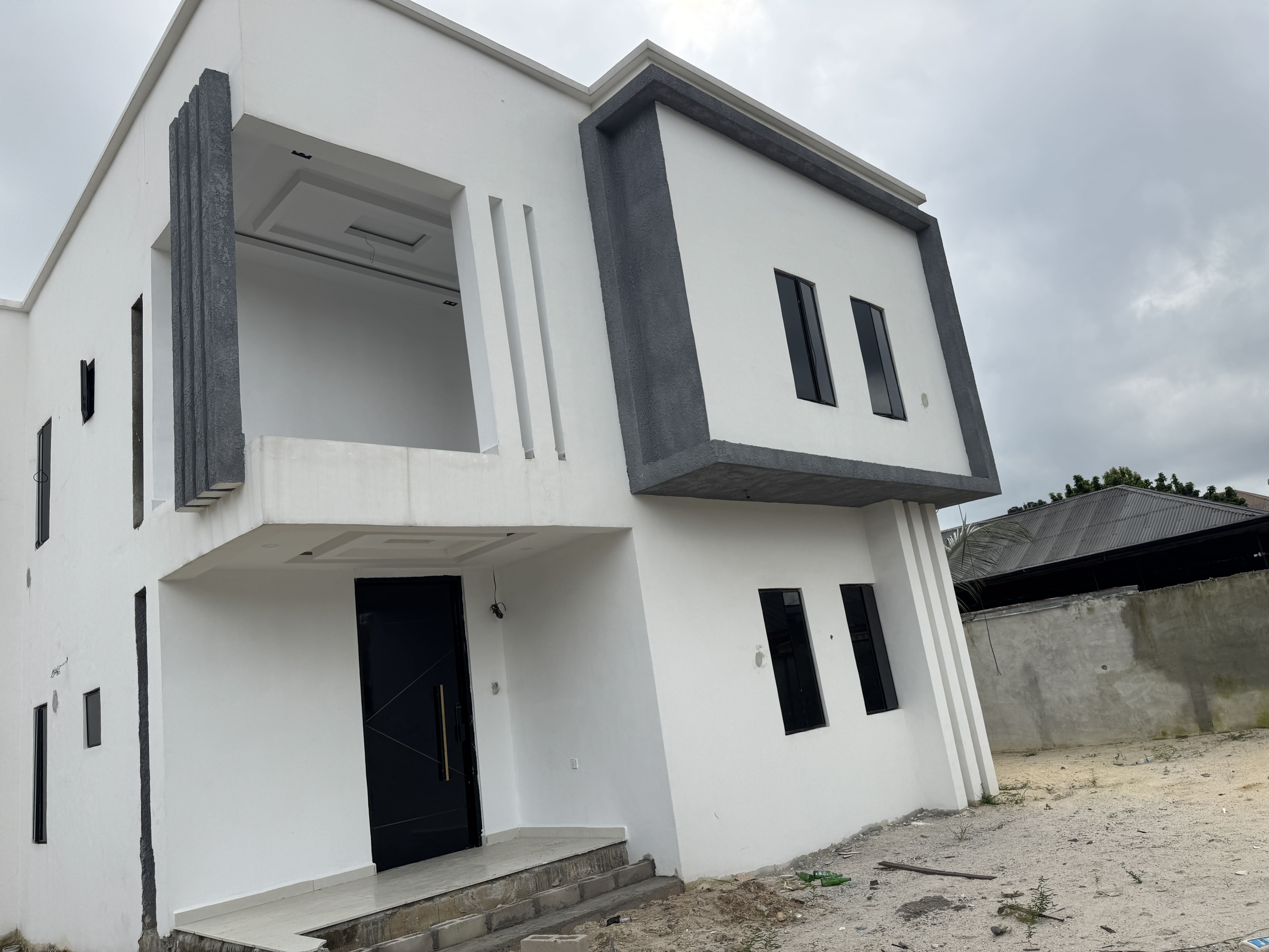 Contemporary white and charcoal facade of the Thambama City duplex in Rukpokwu